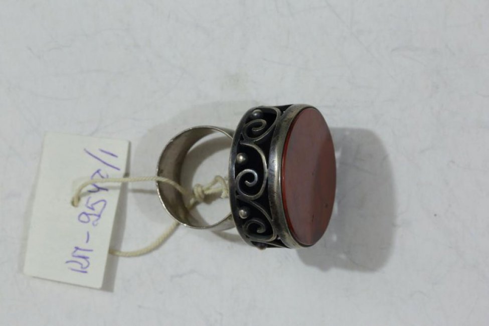 Кольцо круглое, с яшмой в металлической оправе, украшенное зернью и завитками проволоки, образующими "прорезной" корпус. Кольцо плоское.