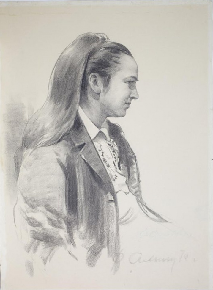 Погрудное изображение женщины в профиль с длинными, убранными в  хвост волосами, в темном жакете белой блузке.