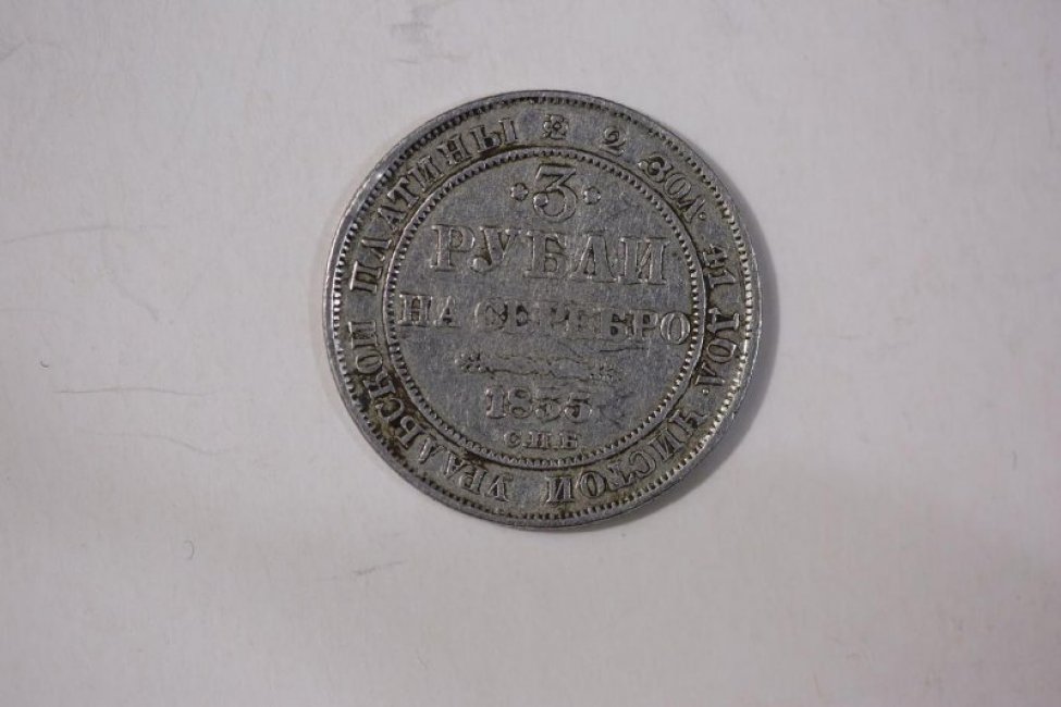 На лицевой стороне монеты надписи: "3 рубли на серебро СПБ", "2 зол. 41 дол. чистой уральской платины". На обороте герб Российской империи.