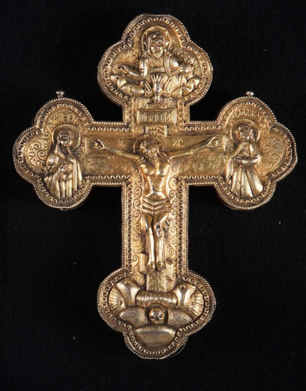  Крест позолоченный, открывающийся, полый внутри, с чеканными изображениями на лицевой стороне: распятия с предстоящими, вверху - Саваофа, внизу- Голгофы и головы Адама.