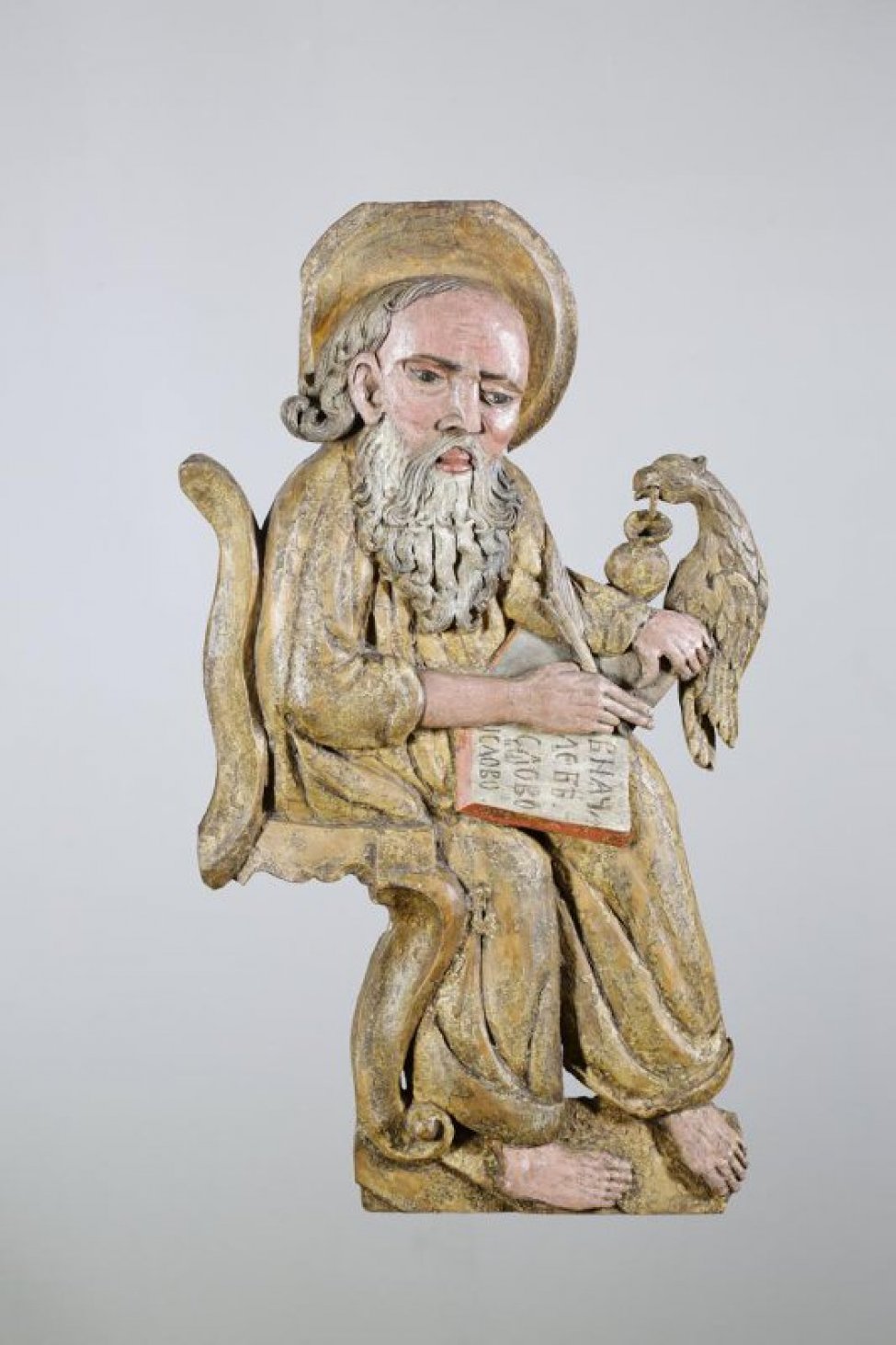 Евангелист Иоанн изображен сидящим, левой рукой поддерживает книгу со словами: "В начале бе слово...". На голове - нимб.