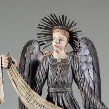 Ангел стоит в нижнем ряду справа в рост. Изображен с поднятой правой рукой и опущенной левой. Одежды: верхняя - позолочена, нижняя - посеребрена. Крылья опущенные, посеребренные.