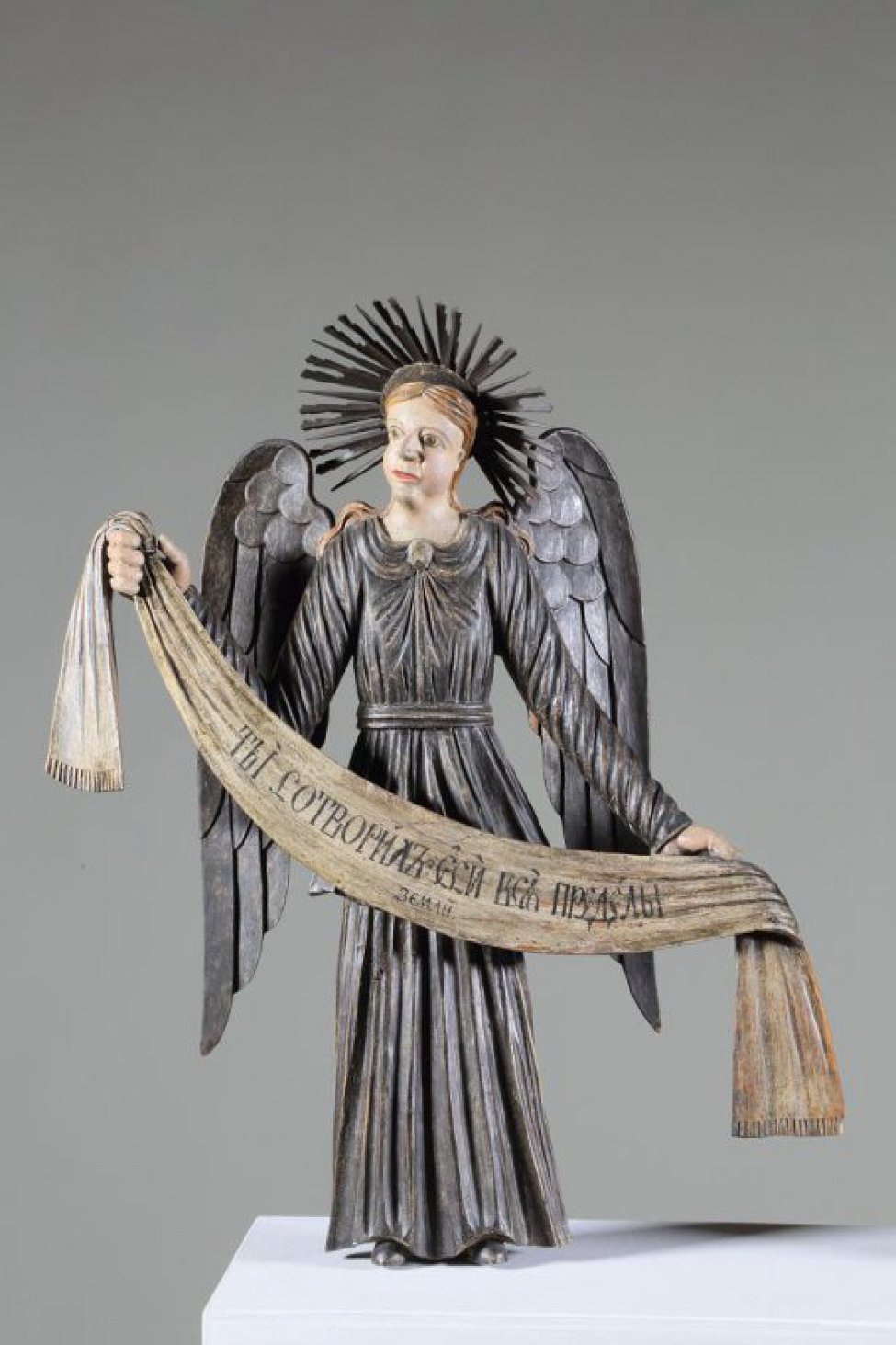 Ангел стоит в нижнем ряду справа в рост. Изображен с поднятой правой рукой и опущенной левой. Одежды: верхняя - позолочена, нижняя - посеребрена. Крылья опущенные, посеребренные.