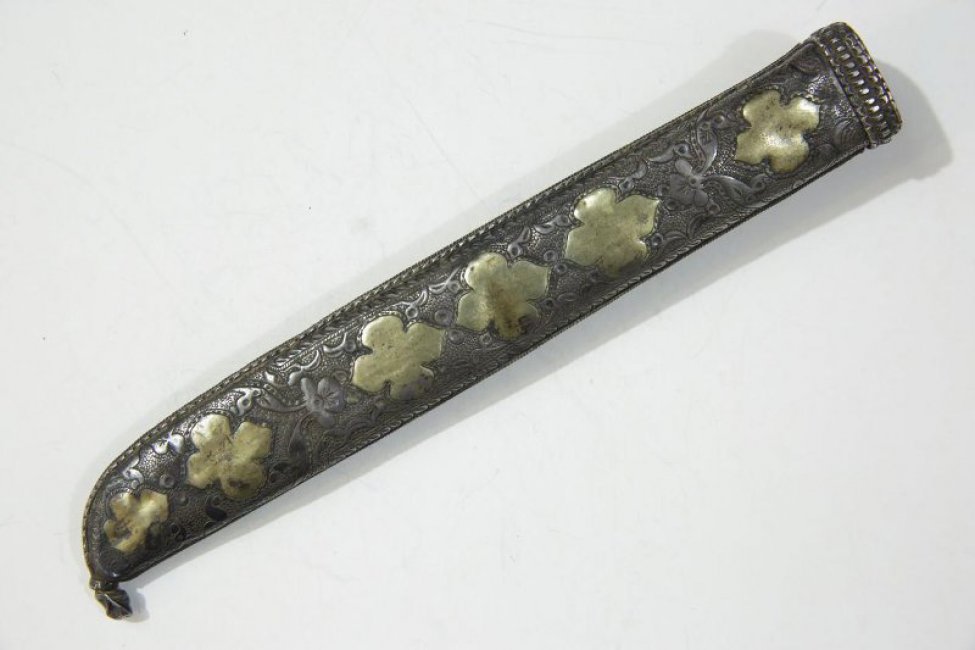 Ножны украшены разнообразным орнаментом: по центру - растительным, с другой стороны - цветочным четырехлепестковым. На одной стороне ножен четыре скобки.