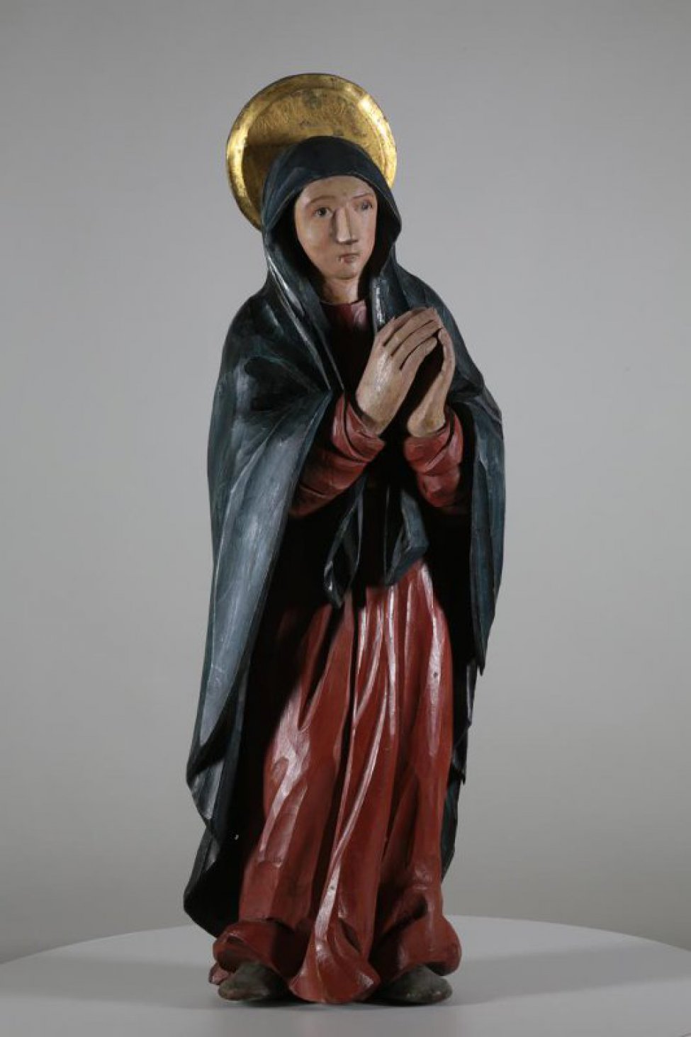 Изображена со сложенными руками и направленными влево, к кресту. На ней красный гиматий и синий хитон.