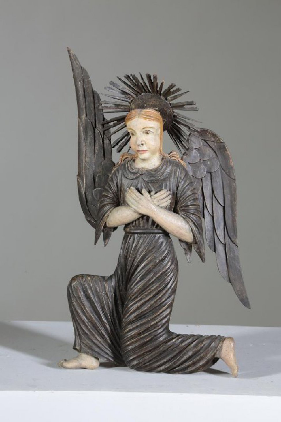 Ангел стоит в верхнем ряду. Изображен со скрещенными на груди руками, в одежде с короткими до локтей рукавами, стоящим по направлению к Саваофу, на левом колене и полусогнутой правой ноге; грудь и голова ангела изображены фронтально; правое крыло имеет взмах вверх.
