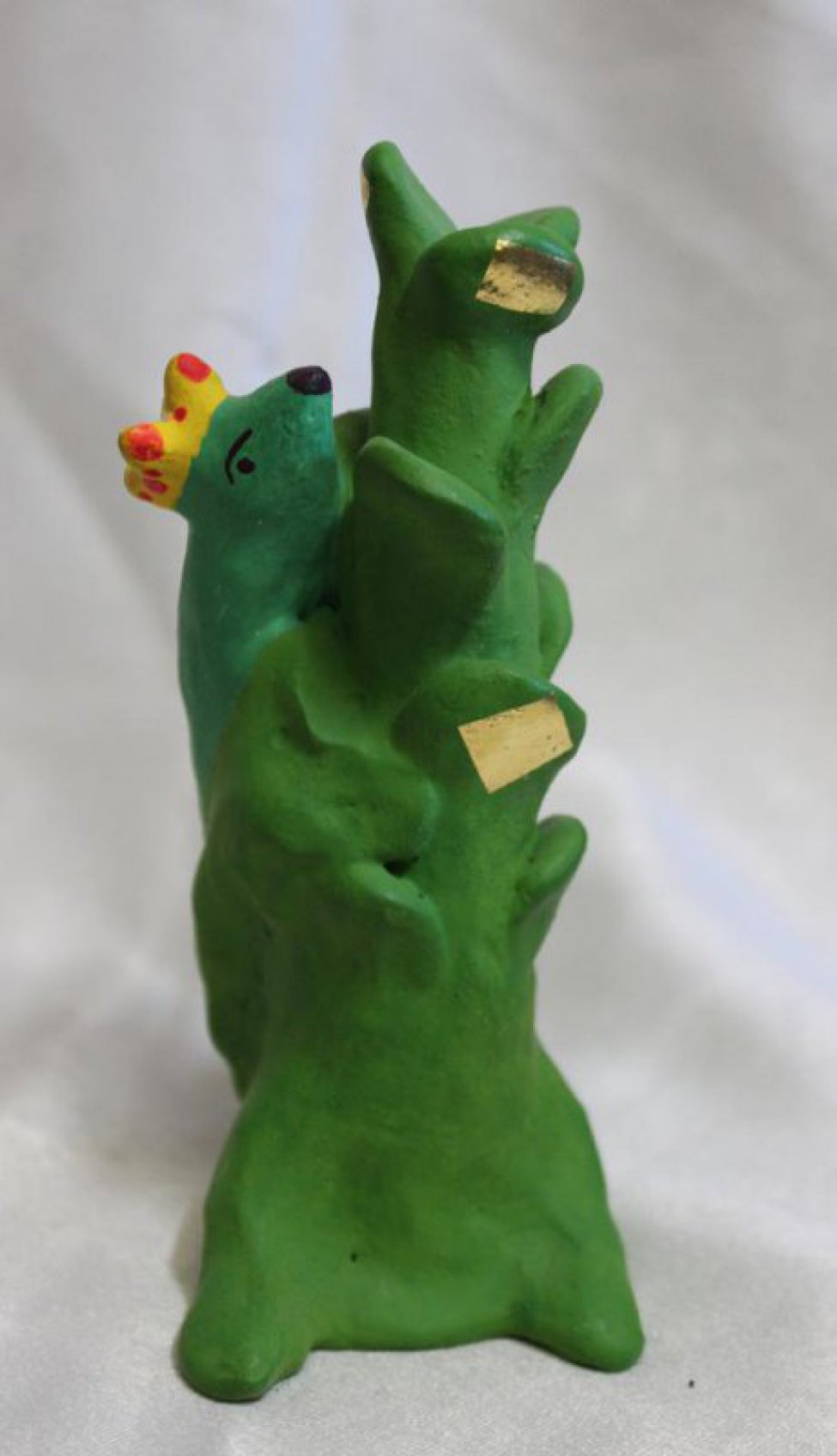 Условное изображение зеленого дерева, на нем ящерица в желтой короне.