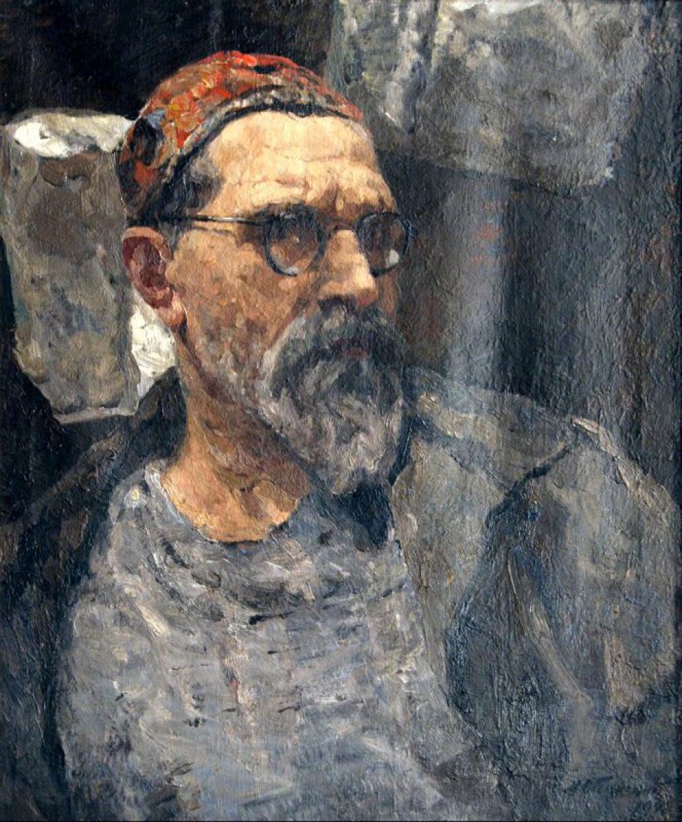 Изображен погрудно пожилой мужчина с седоватой бородкой, в очках, в цветной тюбетейке на голове.