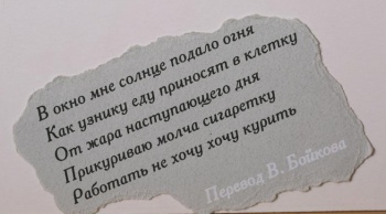 На обрывке серой плотной бумаги текст черной краской в пять строк на русском языке, внизу - фраза 