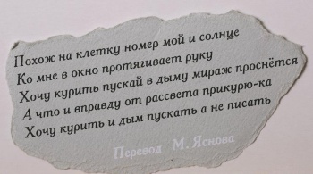 На обрывке серой плотной бумаги  текст черной краской в пять строк на русском языке, внизу - фраза 