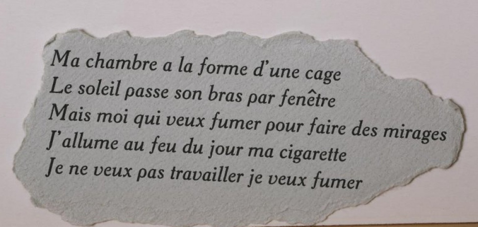 На обрывке серой плотной бумаги текст в пять строк на французском языке