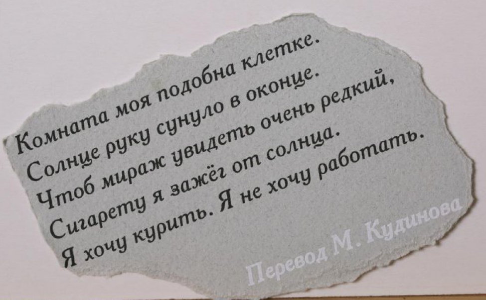 На обрывке серой плотной бумаги текст черной краской в пять строк на русском языке, внизу - фраза "Перевод М. Кудинова" выполнена белым.