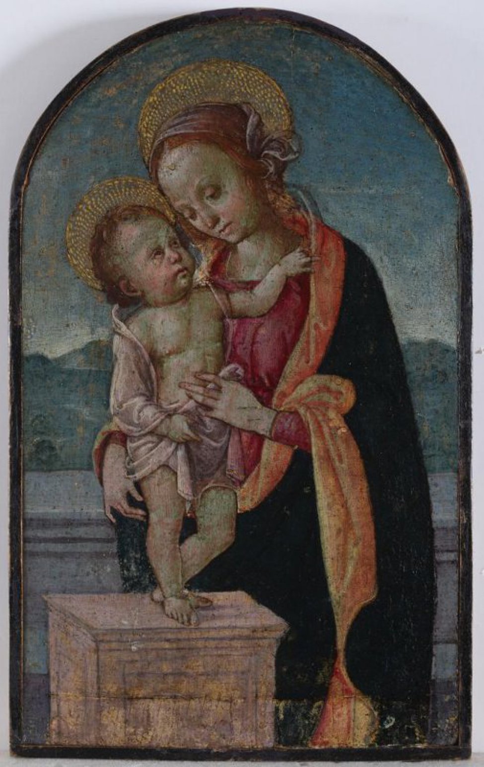 Поколенное изображение мадонны в темной и светло-красных одеждах. поддерживающей младенца, стоящего на столе. Поворот лица и фигуры богоматери влево, младенца - вправо.