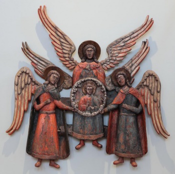 Композиция состоит из трех архангелов; на среднем, стоящем прямо, находится рельефное в обрамлении изображение благословляющего Эммануила; это изображение поддерживают обращенными друг к другу руками два архангела по сторонам; их другие руки подняты на грудь. Архангел справа изображен в небольшом повороте влево. Архангел слева имеет некоторый поворот вправо. На архангелах изображено по две одежды, окрашенных в красный и синий цвета. У крайних архангелов некоторые одежды вырезаны отошедшими с боков на стороны. Изображения архангелов исполнены в ограниченное число плоскостей. Отдельно вырезанные крылья окрашены в серый цвет.