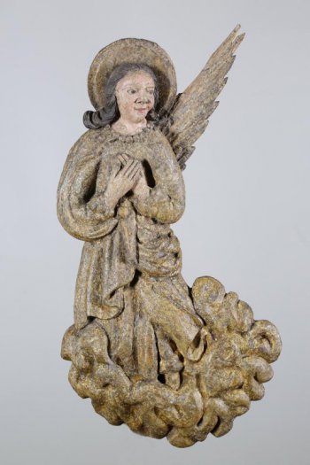 Голова ангела повернута влево, руки скрещены на груди. Волосы длинными вьющимися локонами спускаются на плечи. На голове - нимб. На спине находится отдельно вырезанные два крыла, поднятые концами вверх.