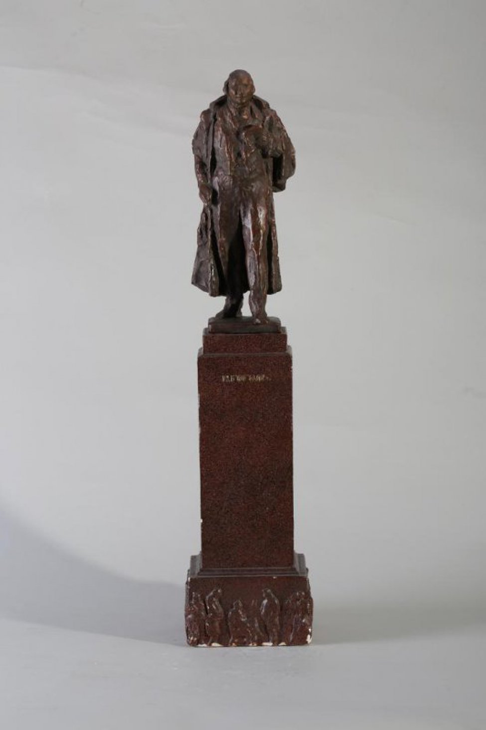 Фигура Гоголя с обнаженной головой, с книгой и бумагой в его левой руке, с выдвинутой вперед левой ногой. На постаменте.