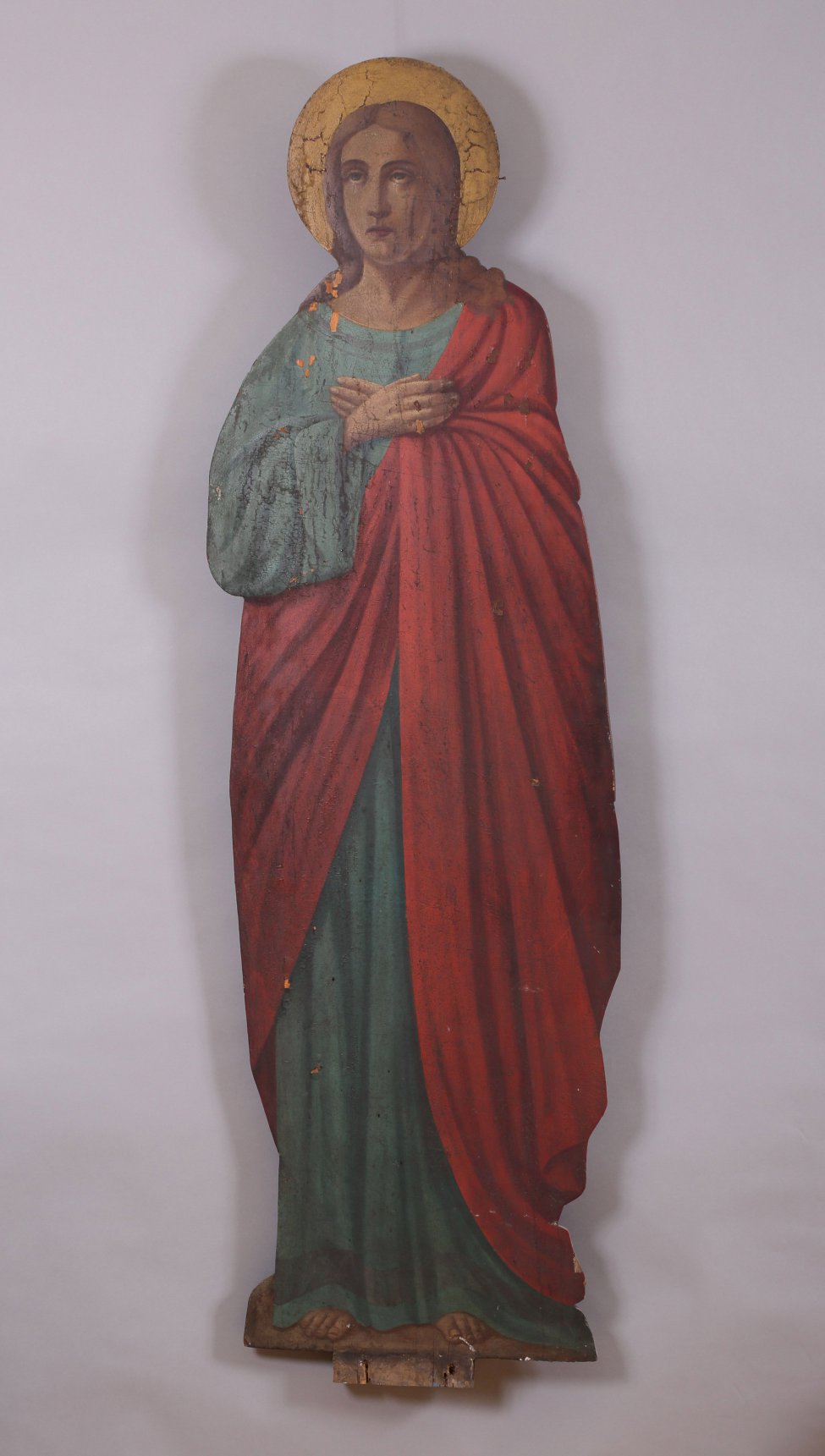 Фигура Иоанна Богослова исполнена живописно по дереву. Богослов изображен со скрещенными на груди руками, в зеленом хитоне и красном гиматии. Над головой - нимб.