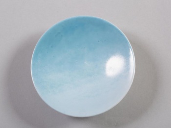 Круглая, полая, с высоким рифленым бортиком, зеркало овальной формы серо-голубого цвета.