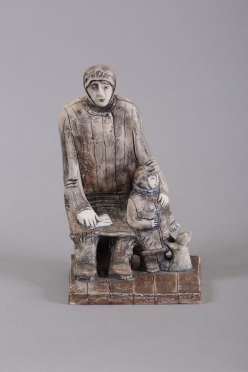 На четырехугольном неправильной формы основании изображена фигура сидящей женщины с письмом на коленях, слева от нее стоит мальчик с кошкой.