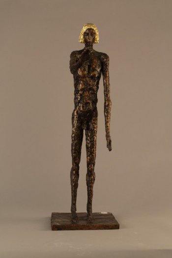На прямоугольном основании изображена в полный рост стилизованная фигура обнаженного мужчины с волосами золотистого цвета. Левая рука опущена, правая вытянута вперед. На спине глубокие впадины.