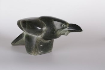 Скульптура выполнена в камне черного цвета. Фигура ворона выполнена объемно - мощный клюв переходит в объем головы, шеи. Конусообразно выделено опререние птицы. Основание скульптуры образует куб неправильной формы.