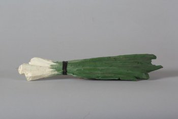 Обобщенное изображение перьев лука темно-зеленого цвета, с белыми головками, перевязанных черной лентой. На конце головки - треугольное крепление.