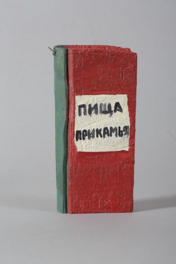 Обобщенное изображение книги красного цвета, корешок зеленый. На передней обложке белый квадрат с надисью: ПИЩА ПРИКАМЬЯ. На корешке вверху треугольное крепление.