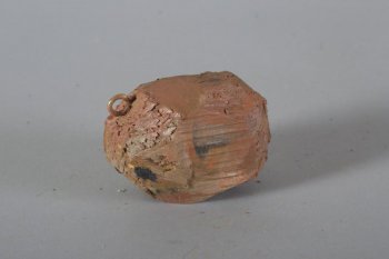 Обобщенное изображение картофелины коричневого цвета, с редкими смазанными черными пятнами. Вверху сбоку металлическое кольцо.