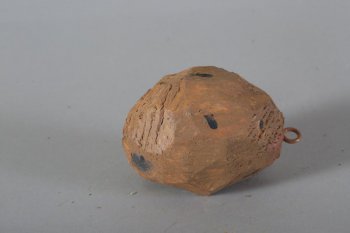 Обобщенное изображение картофелины коричневого цвета, с редкими мелкими и большими черными пятнами. Наверху металлическое кольцо.