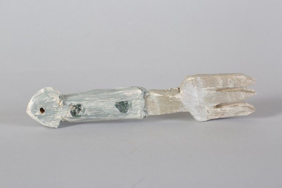 Обобщенное изображение вилки с тремя зубцами серебристо-белого цвета. Ручка бело-серая, с обеих сторон вырезаны по два круглых углубления, с треугольным навершием, в котором высверлено сквозное отверстие.