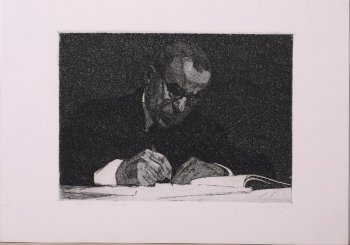 Изображен сидящий за столом мужчина в очках, с карандашом в правой руке. Перед ним лежит альбом.