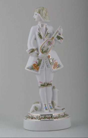 Скульптурное изображение юноши на круглом постаменте с музыкальным инструментом в руках, у ног лежащая собака. Камзол и постамент расписаны цветочным орнаментом.