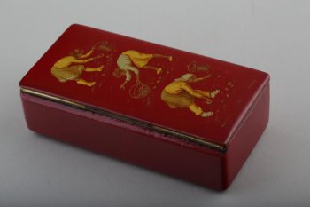 Прямоугольная коробочка темно-красного цвета, с крышкой. На крышке изображены три женщины за посадкой картофеля: боковые - с ведрами, средняя - с корзинкой.