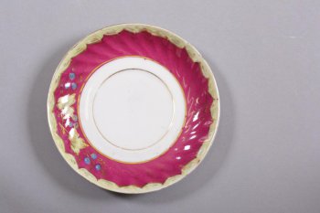Круглое, на кольцевой ножке; борт рифленый, декорирован цветочной росписью и золочением по бордовому фону
