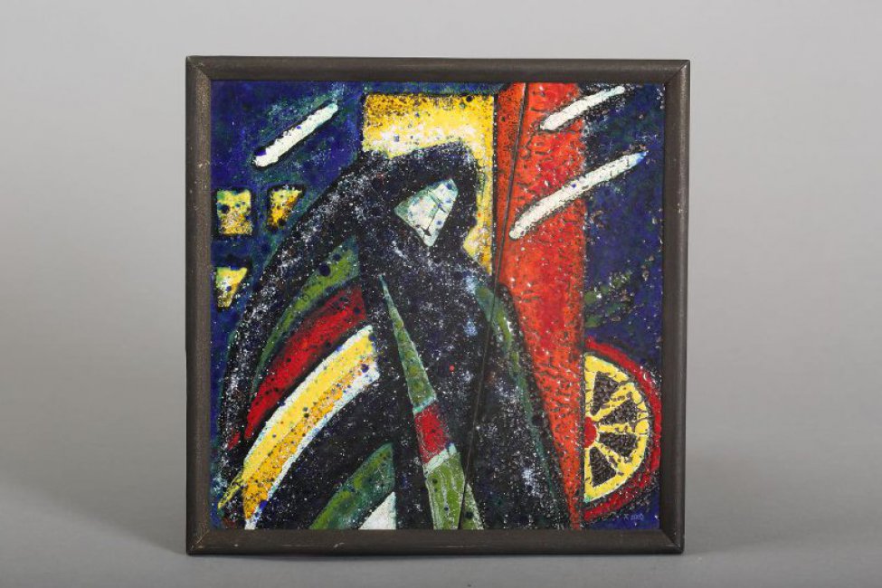 Двухчастная эмалевая пластина заключена в деревянную черную раму. Композиция эмали стилизованная: изображена фигура в цветном облачении и черном покрывале на голове. Слева - фрагмент желто-красного колеса?