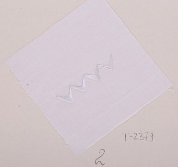 На белом батисте квадратной формы в центре дан образец последовательности выполнения шитья гладью. Образец в виде четырех уголков. Образец приклеен к картонному листу.