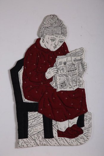 По абрису вырезана сидящая женская фигура в темно-красном платье, с газетой в руках, на черном стуле.  Рисунок фигуры  вышит черными нитями.  Женщина изображена вправо, с высокой прической, с овальной серьгой в ухе, в темно-красных туфлях, платье расшито отдельными белыми крестиками, в тексте газеты слова: 