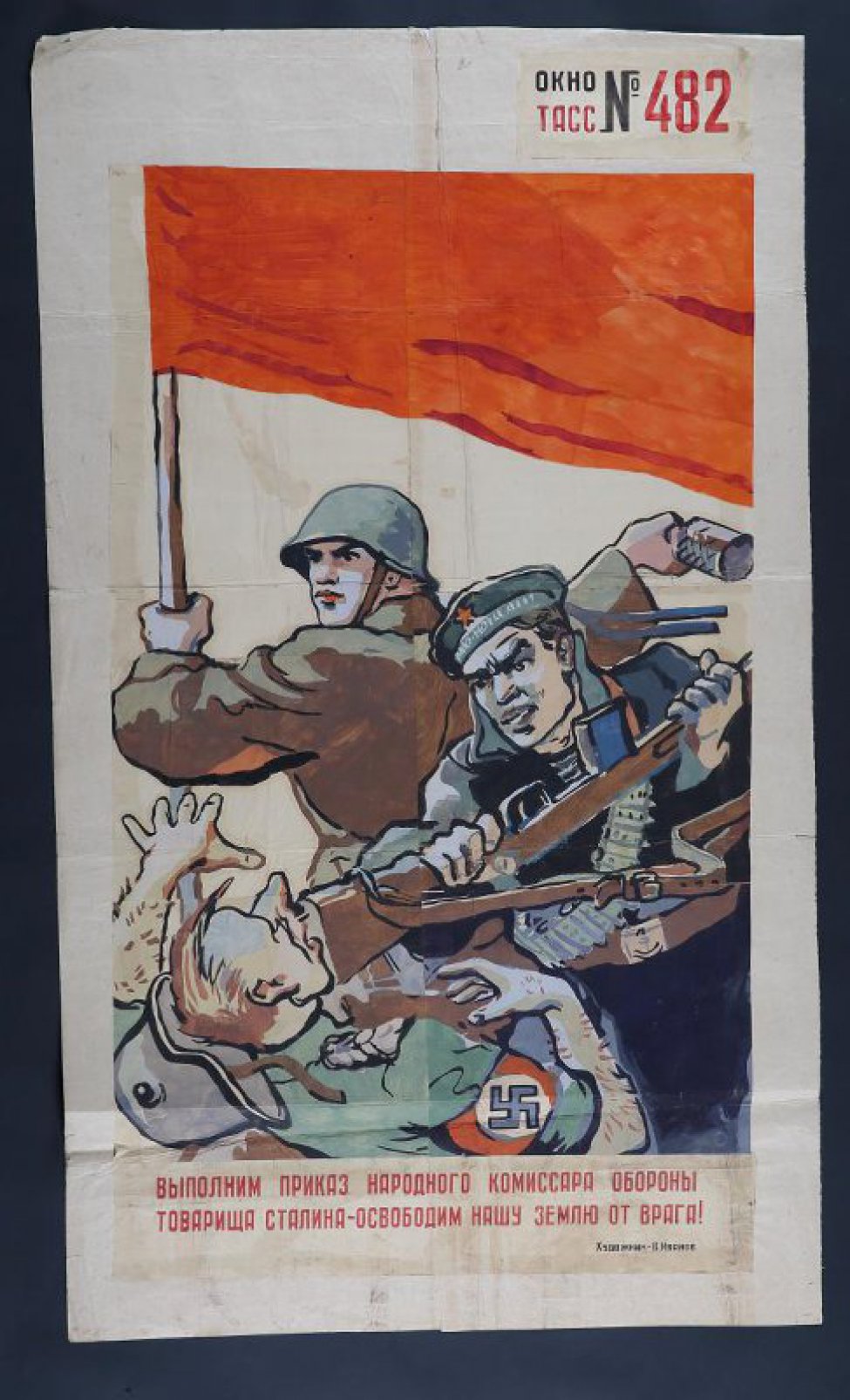 Изображено: под красным знаменем советский воин бросает гранату, моряк бьет прикладом фашиста по лицу, текст: " Выполним приказ народного комиссара Обороны товарища Сталина- освободим нашу землю от врага."