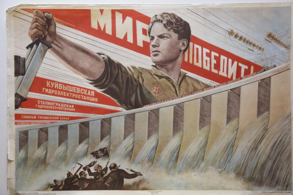 Изображено: в верхней части молодой человек с орденом Отечественной войны, включает рубильник. Внизу- из плотины хлещет вода на поджигателей войны.