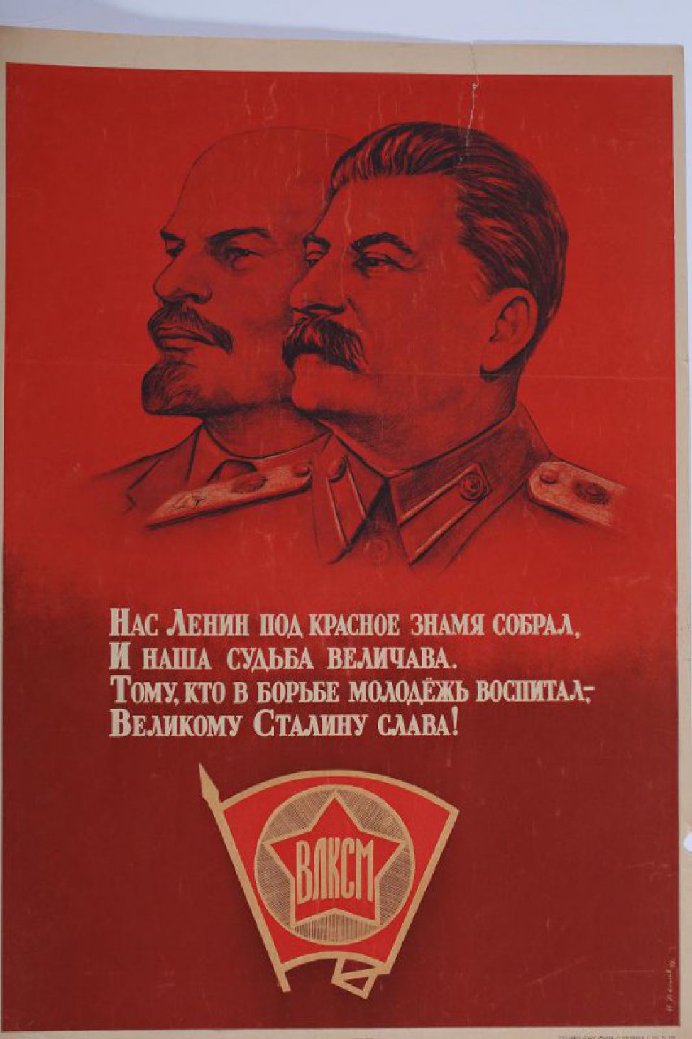 Изображены вверху на красном фоне портреты Ленина и  Сталина. Внизу - комсомольский значек, а между ними текст: "Нас Ленин под красное знамя собрал, и наша судьба величава!"