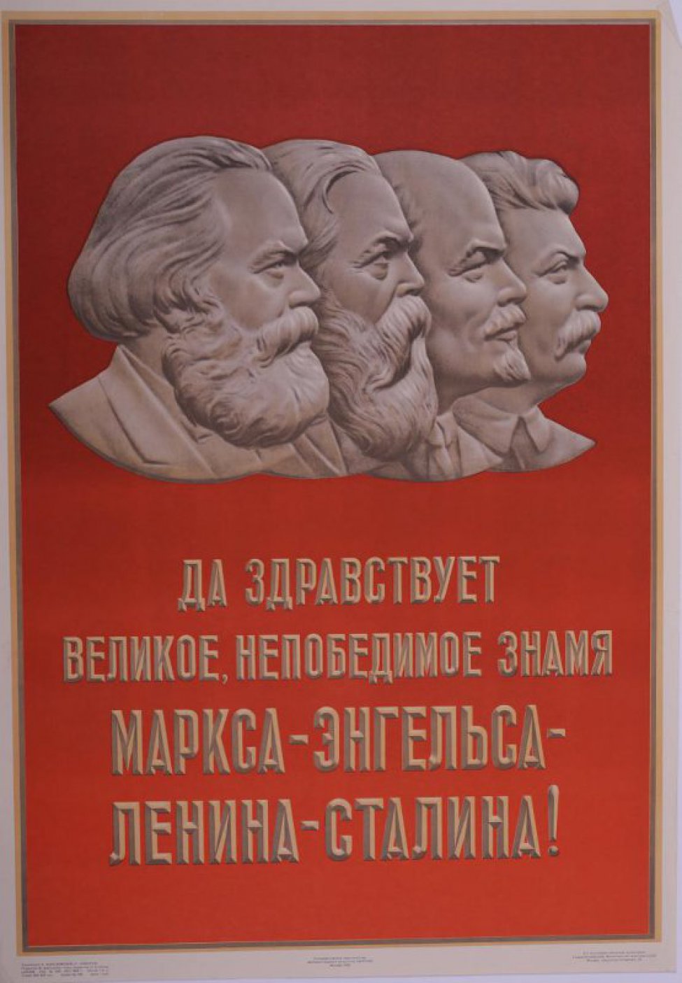 В верхней части плаката изображены портреты: К.Маркса,Ф.Энгельса, В.И.Ленина и И.Сталина. Внизу текст: " Да здравствует великое непобедимое знамя Маркса-Энгельса-Ленина-Сталина!"