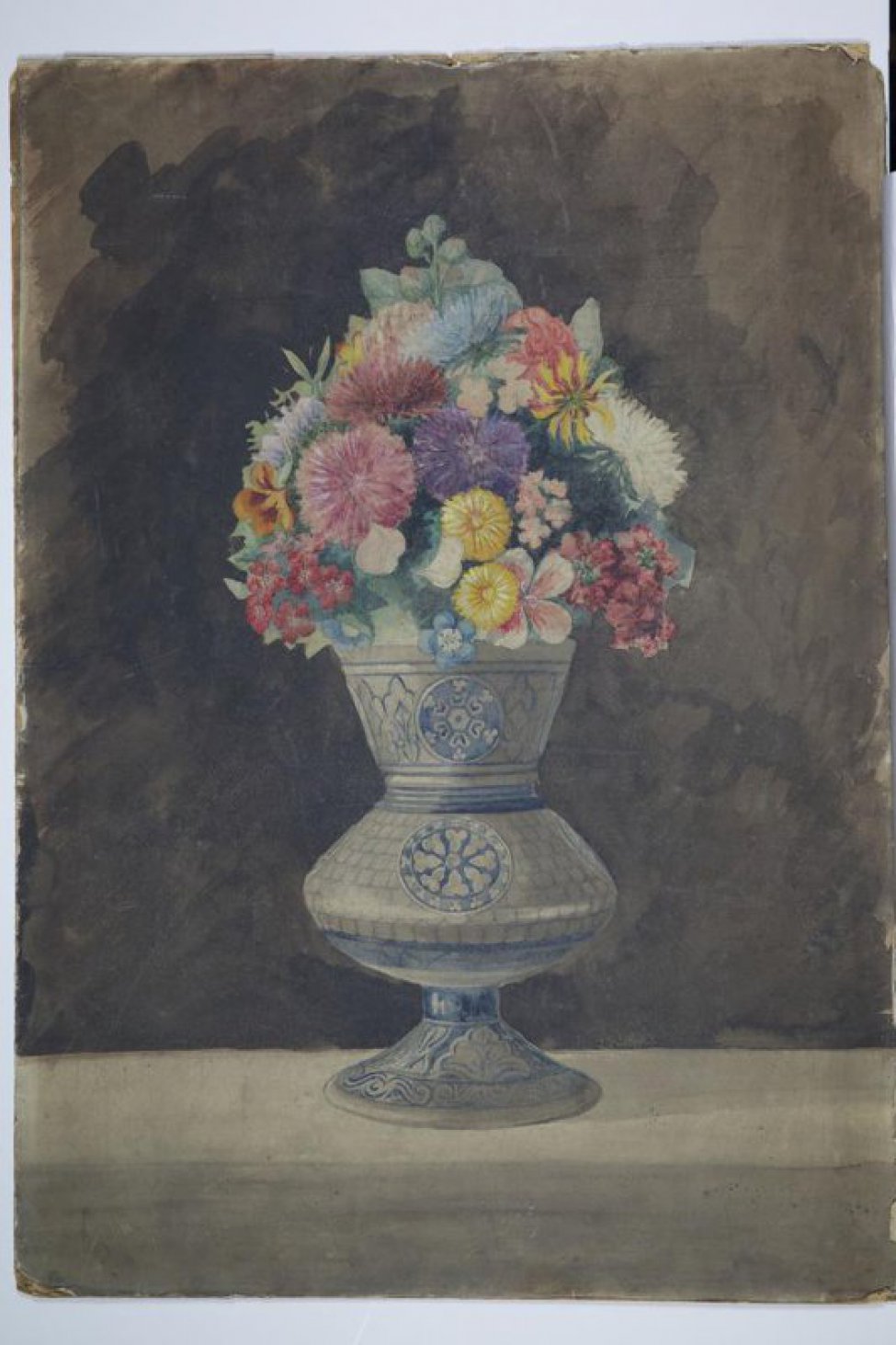 На серовато-коричневом фоне изображен букет цветов - красных астр, желтых бессмертников и других цветов, поставленных в серую вазу, с растительным синим  орнаментом.