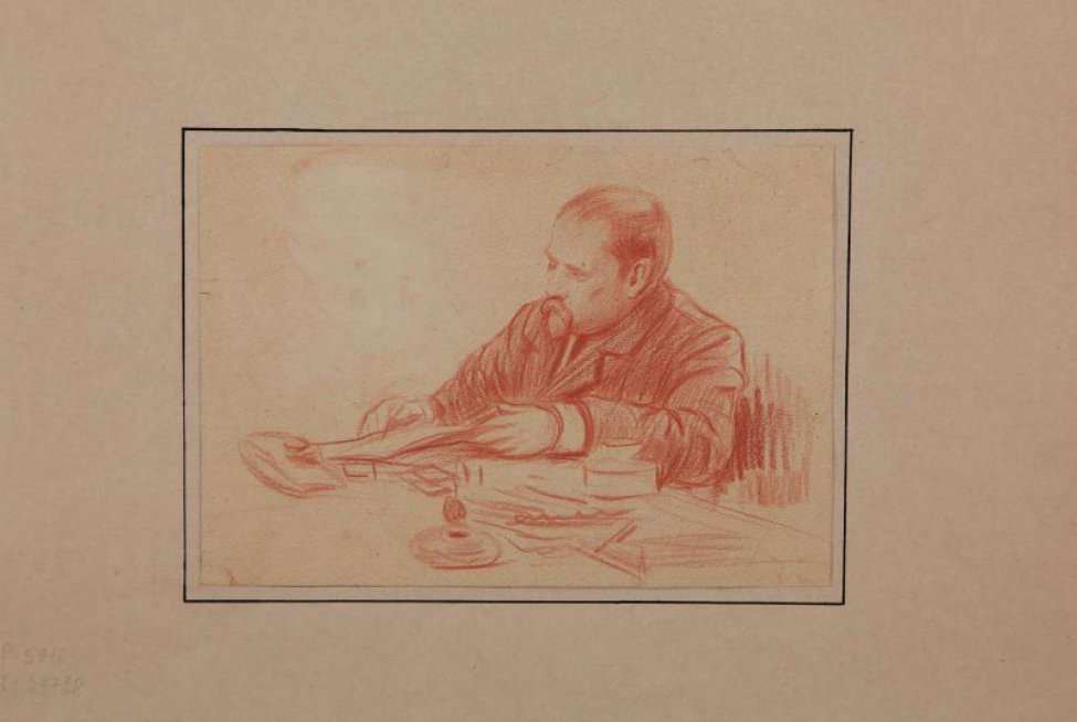 Изображен погрудно сидящий за столом средних лет мужчина с бородкой, в пиджаке, читающий газету.