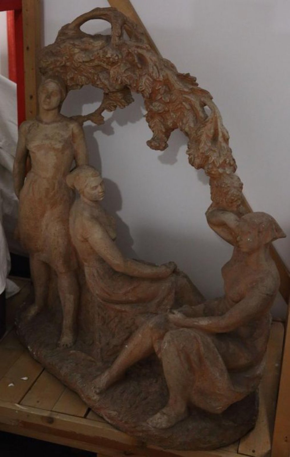 Три молодые женские фигуры у виноградного куста, одна - слева стоящая, две - сидящие; босые, в косынках на голове, одеты в летние платья. Справа у куста фигура стоит отставив левую ногу, руки за спиной, правая - согнута в локте. В центре, прислонившись к левому бедру стоящей, сидящая спиной к зрителю женщина на коленях, правая рука с виноградной кистью. Ноги скрещены. Справа сидящая лицом к зрителю - правой рукой у плеча придерживает свешивающуюся виноградную ветвь, левая - свободно лежит на коленях.