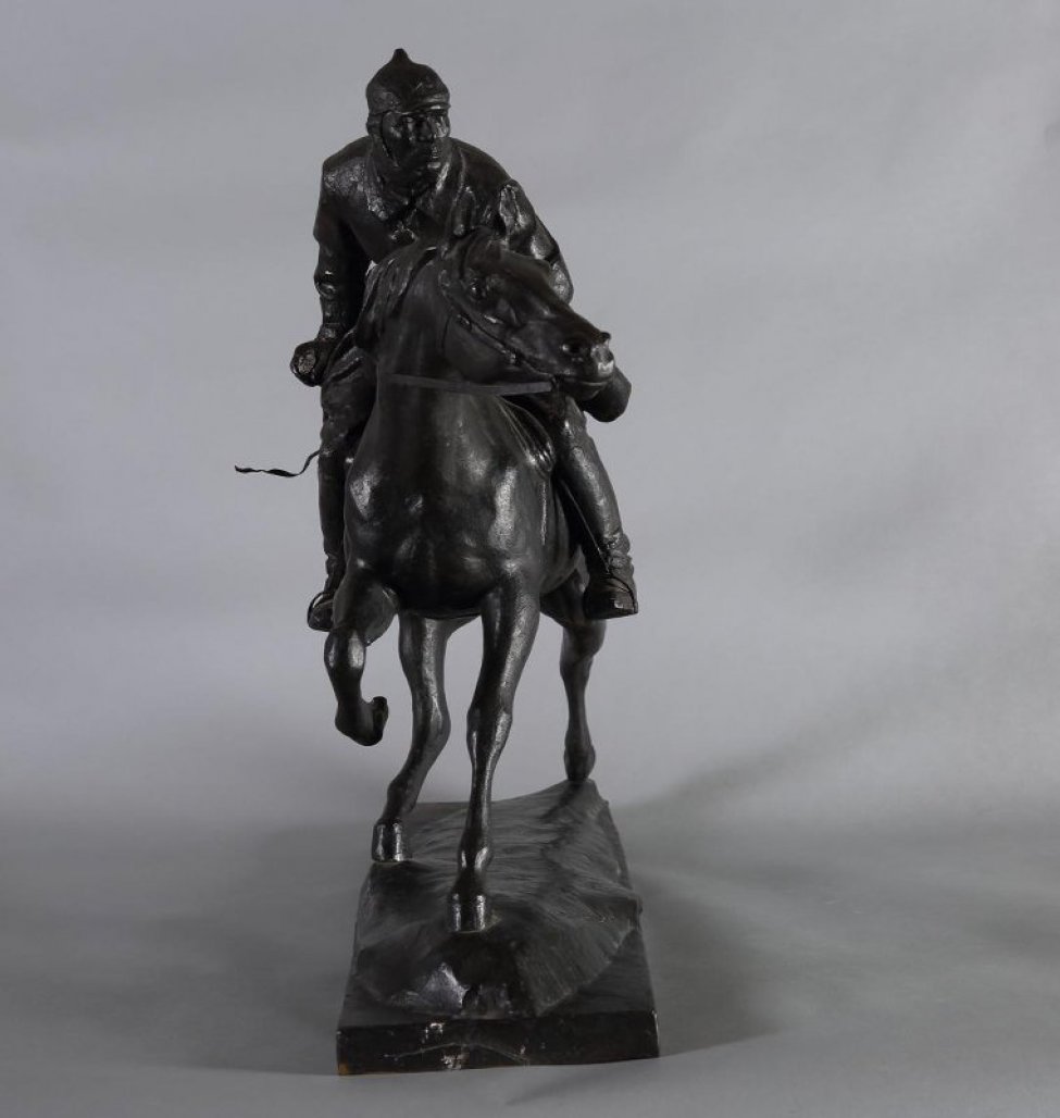 Изображен красноармеец верхом на коне, пригнувшись к шее лошади, он всматривается вдаль. Он в шлеме и шинели, на левом боку сабля, в правой руке- винтовка.