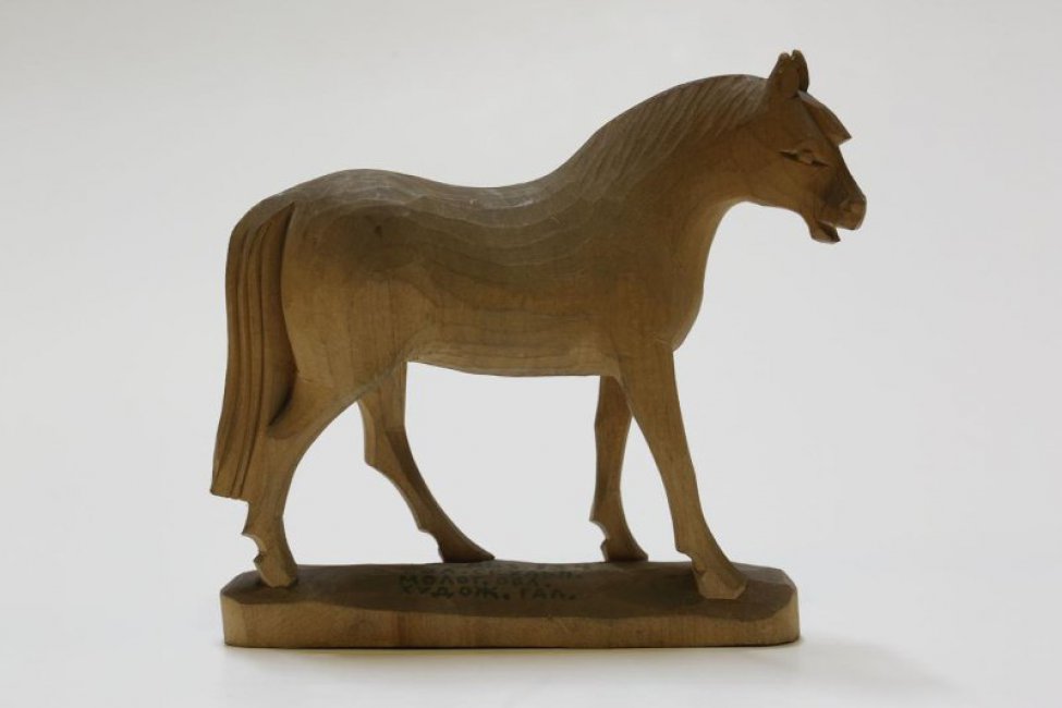Изображена фигура идущего коня с голвой, повернутой немного вправо. Фигура вырезана с постаментом.
Обрамление: Постамент неправильной овальной формы.