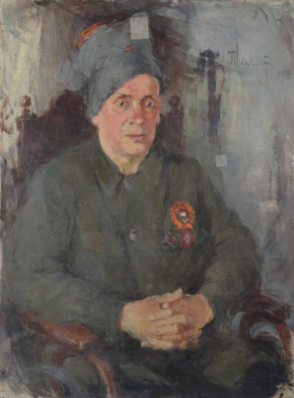 Изображен сидящий Окулов в военном костюме, с орденом на груди, в барашковой шапке. Окулов сидит в кресле. Красное лицо обращено к зрителю.