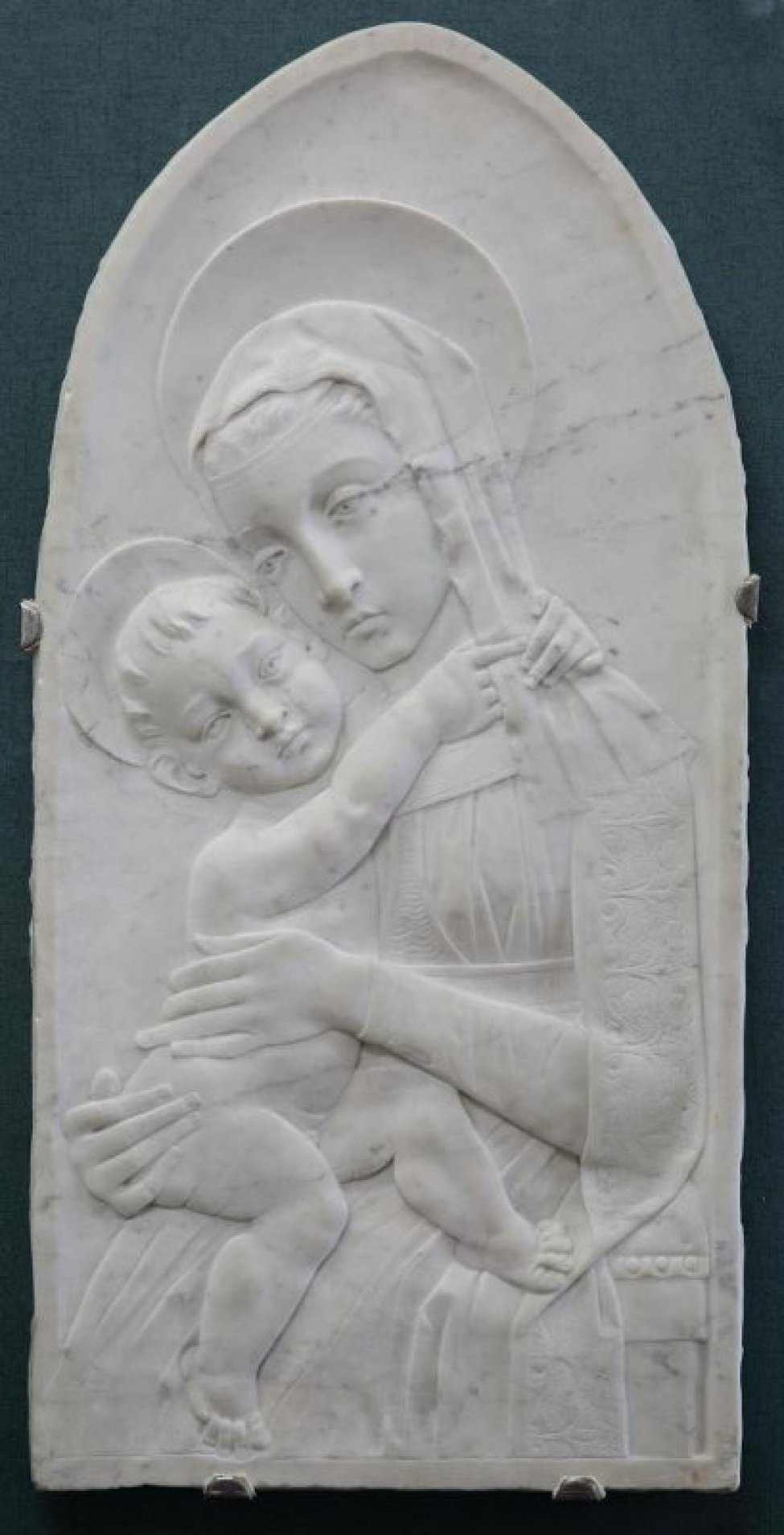 Изображена молодая женщина. Справа у нее на руках находится обнаженный младенец, который обнял женщину за шею.