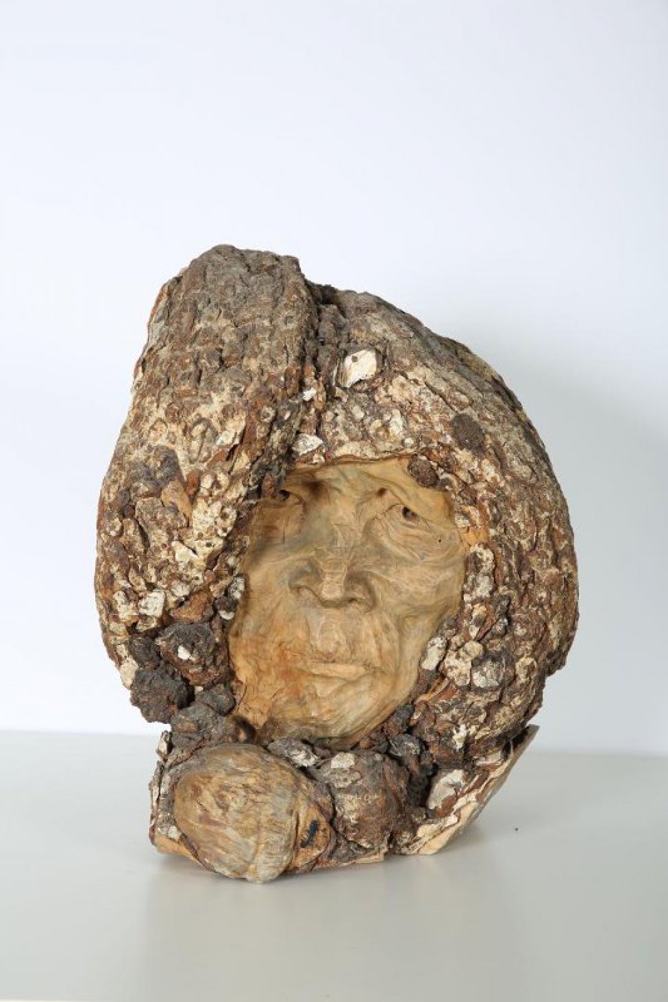 Скульптурное изображение мужской головы в меховом капюшоне (древесная кора). Лицо (дерево) скуластое, с впалыми щеками. Глаза глубоко посажены, широкие ноздри, тонкие губы плотно сжаты.