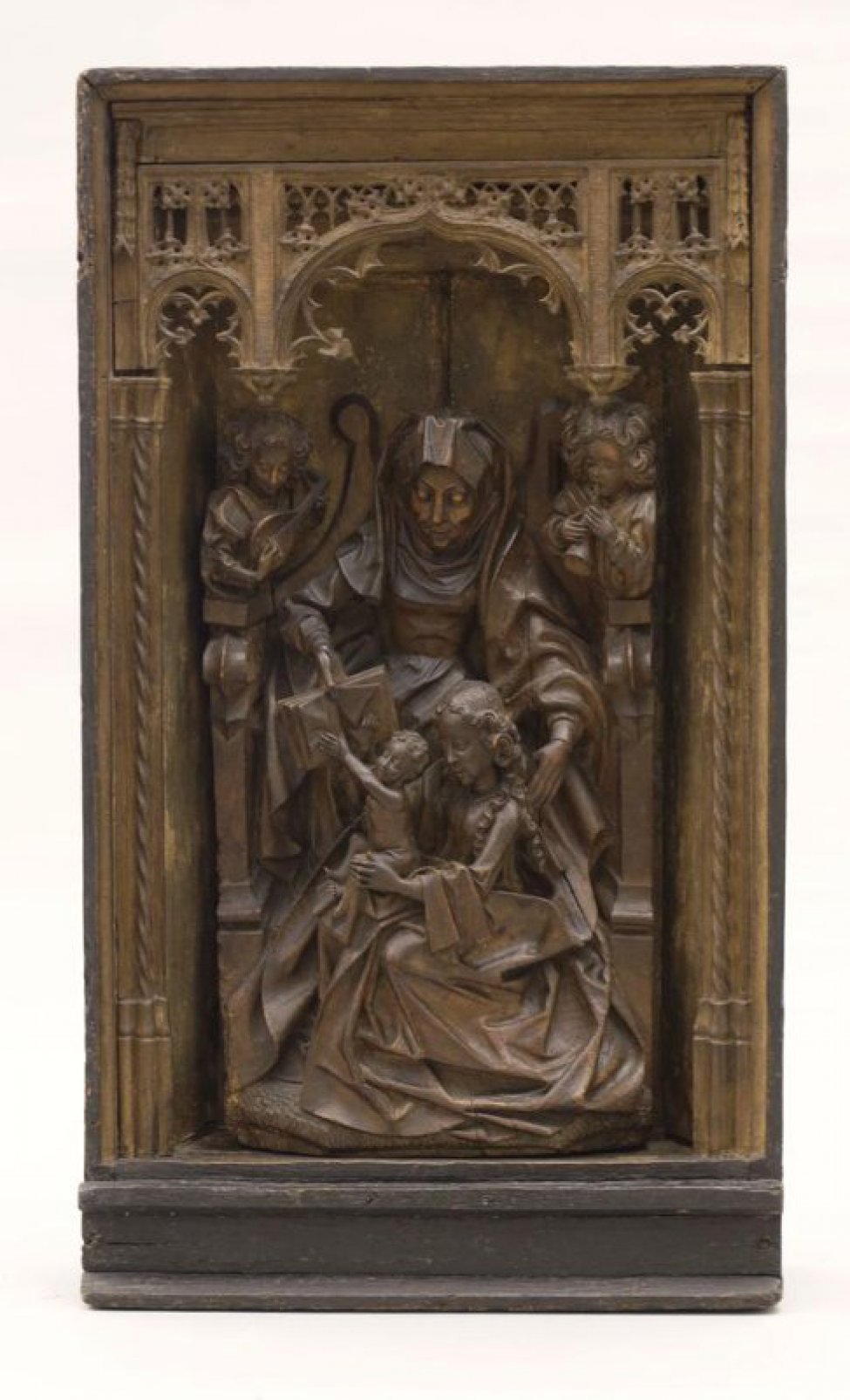 Изображена женщина, сидит на троне в длинной одежде и повязке на голове. В ногах у Св. Анны сидит женщина с младенцем на коленях, который тянется к раскрытой книге, протянутой Анной. За троном с обеих сторон фигуры ангелов.